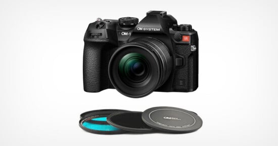 A black OM System OM-1 camera with a large lens is shown above three stacked round camera lens filters with black rims on a white background.