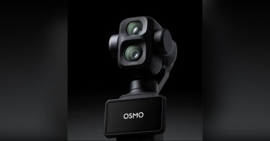 A close-up of a black DJI Osmo camera with dual lenses and a gimbal mount, shown against a dark background. The device has the word "OSMO" displayed on its front panel.
