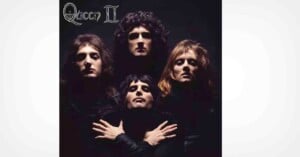 Four people in dark clothing pose dramatically against a black background, with two in back and two in front. The top left corner features the text "Queen II" in a stylized font.