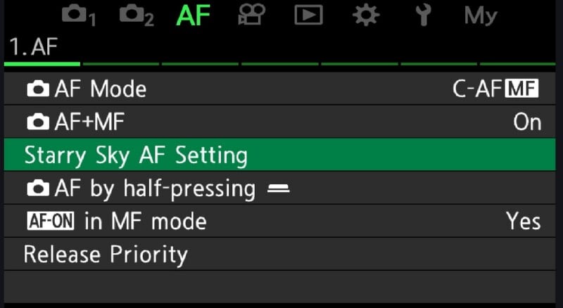 Camera menu screen showing autofocus (AF) settings. "Starry Sky AF Setting" is highlighted in green. Other options listed include AF Mode, AF MF, AF by half-pressing, AF-ON in MF mode, and Release Priority.