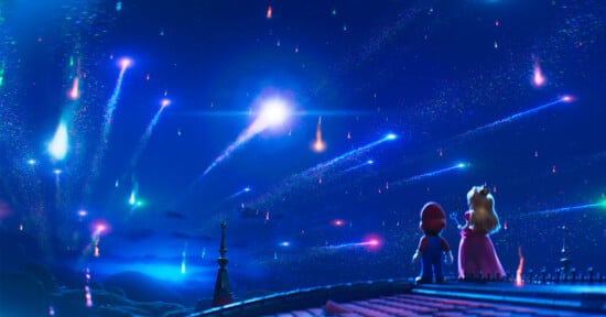 Mario and Princess Peach stand together on a rooftop at night, gazing at a sky filled with colorful shooting stars and glowing trails. The scene is vibrant, magical, and illuminated by the falling stars.