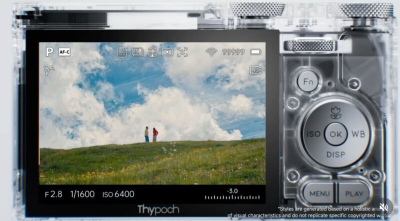 La pantalla de la cámara digital muestra una imagen vívida de dos personas paradas en una colina cubierta de hierba bajo un cielo azul y nubes blancas. Se pueden ver varias configuraciones e íconos de la cámara en la pantalla, y el botón de la cámara se puede ver a la derecha.