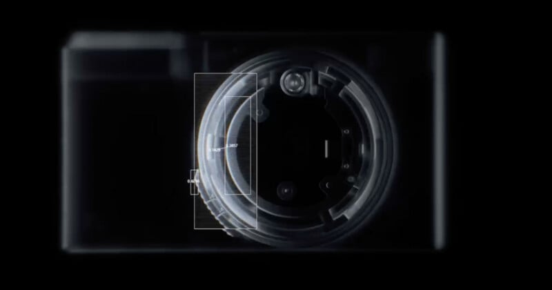 Vista en primer plano, oscura y translúcida de una cámara digital que muestra el conjunto de lentes interno y el área de enfoque rectangular resaltada en el centro.