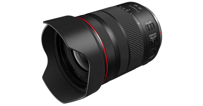 A black camera lens with a red ring near the base and a petal-shaped lens hood, featuring various adjustment switches and markings for focal length and focus.
