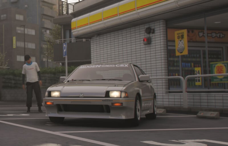 A silver Honda CR-X with "Mugen CRX" on the windshield is parked in front of a convenience store. A person wearing a mask and cap walks nearby. The store has Japanese signs and a tiled exterior.