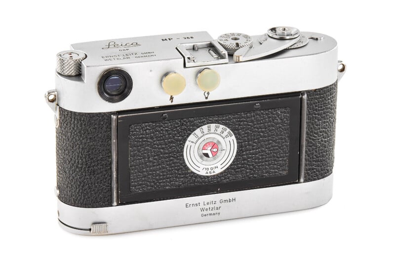 A vintage Leica MP film camera shown from the back, featuring a black textured grip, a round exposure dial, and silver metal top and bottom plates engraved with the Leica logo and manufacturer details.