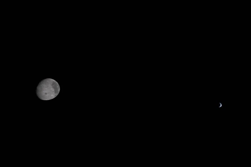A photo of the Moon on the left side of a black sky, with a small, crescent-shaped Earth visible on the far right, showing both celestial bodies surrounded by darkness.