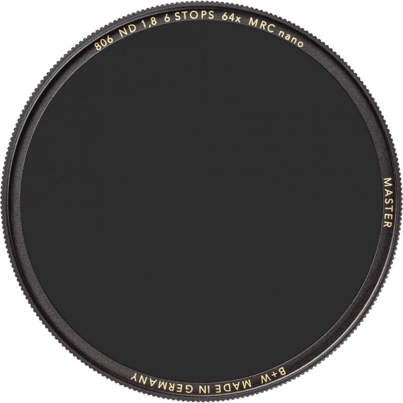 A circular black camera lens filter labeled “B+W Made in Germany 806 ND 1.8 6 STOPS 64x MRC nano MASTER” with gold text on the rim.