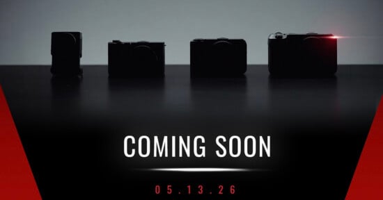 Four silhouetted cameras on a dark background, with one emitting a small red light. Text below reads "COMING SOON" and "05.13.26" in white and red on a black and red gradient background.