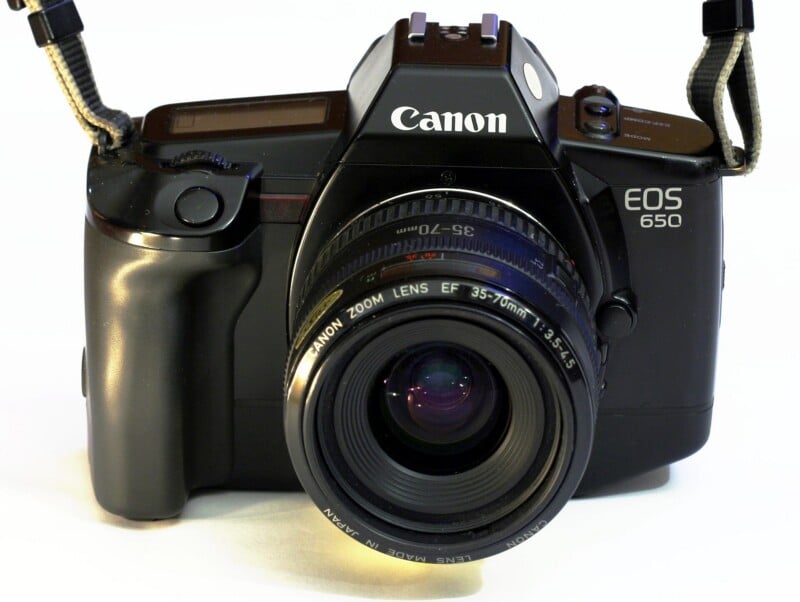 A Canon EOS 650 film camera with a Canon Zoom Lens EF 35-70mm f/3.5-4.5, viewed from the front, showing the lens, body, and camera strap ends.