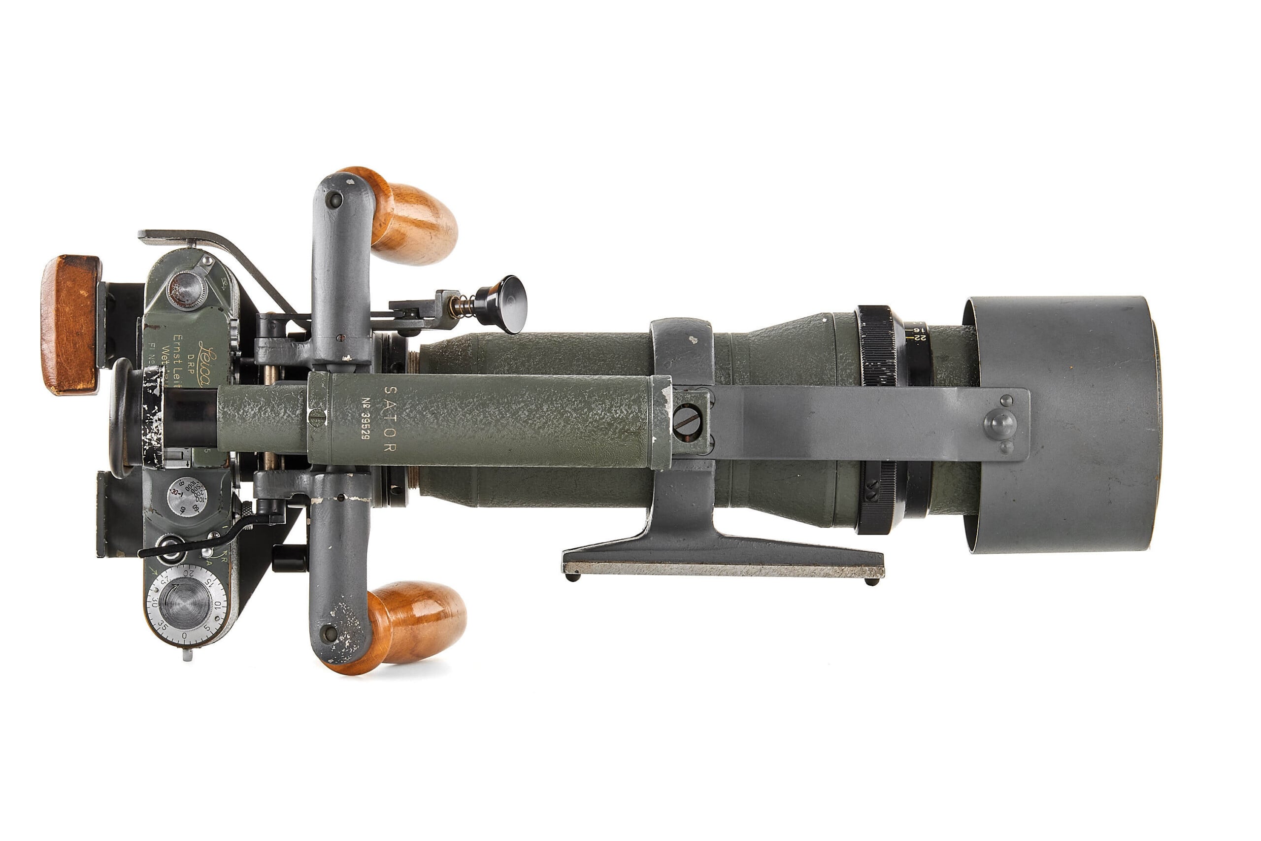 A vintage military optical device with green and gray metal parts, dials, and wooden handles, viewed from above and horizontally aligned on a white background.