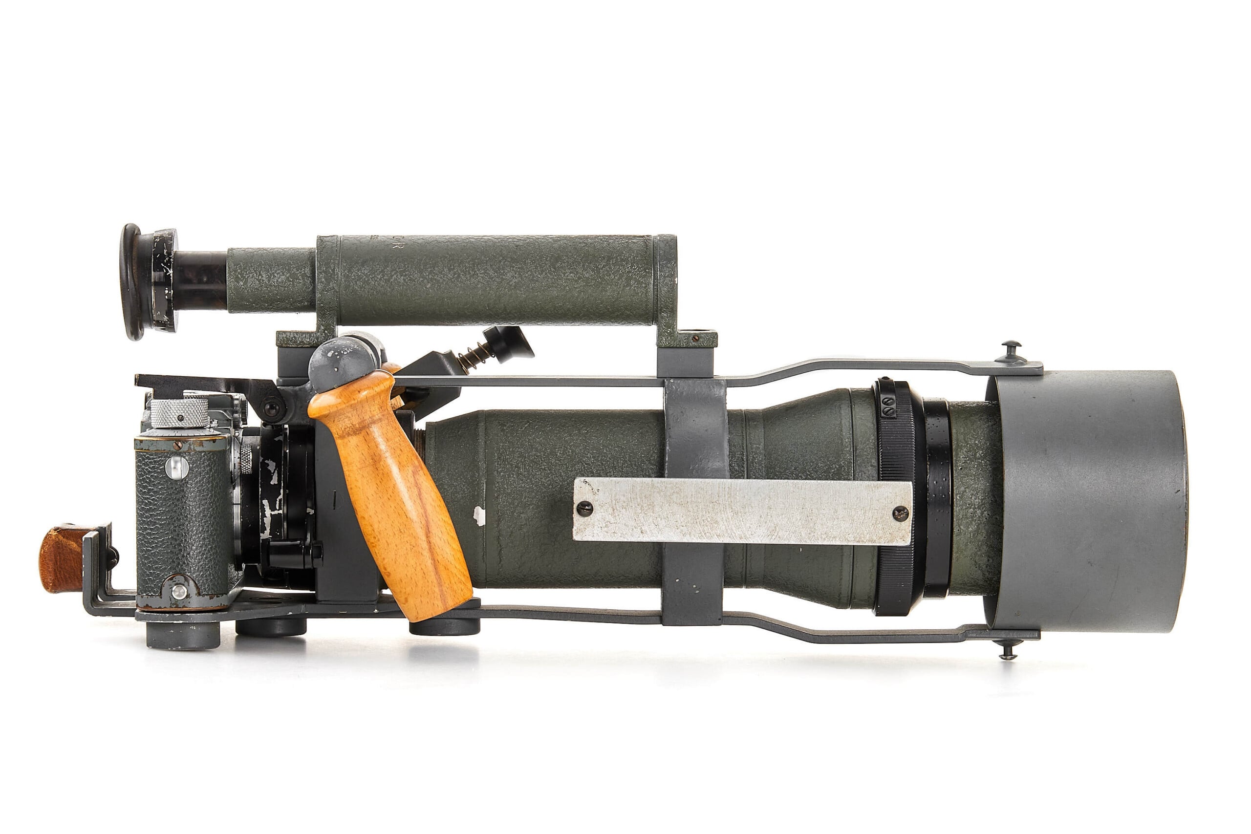A vintage handheld optical device with a gray metal body, wooden grip, and eyepiece, resembling a military rangefinder or scope, shown in a side profile against a white background.