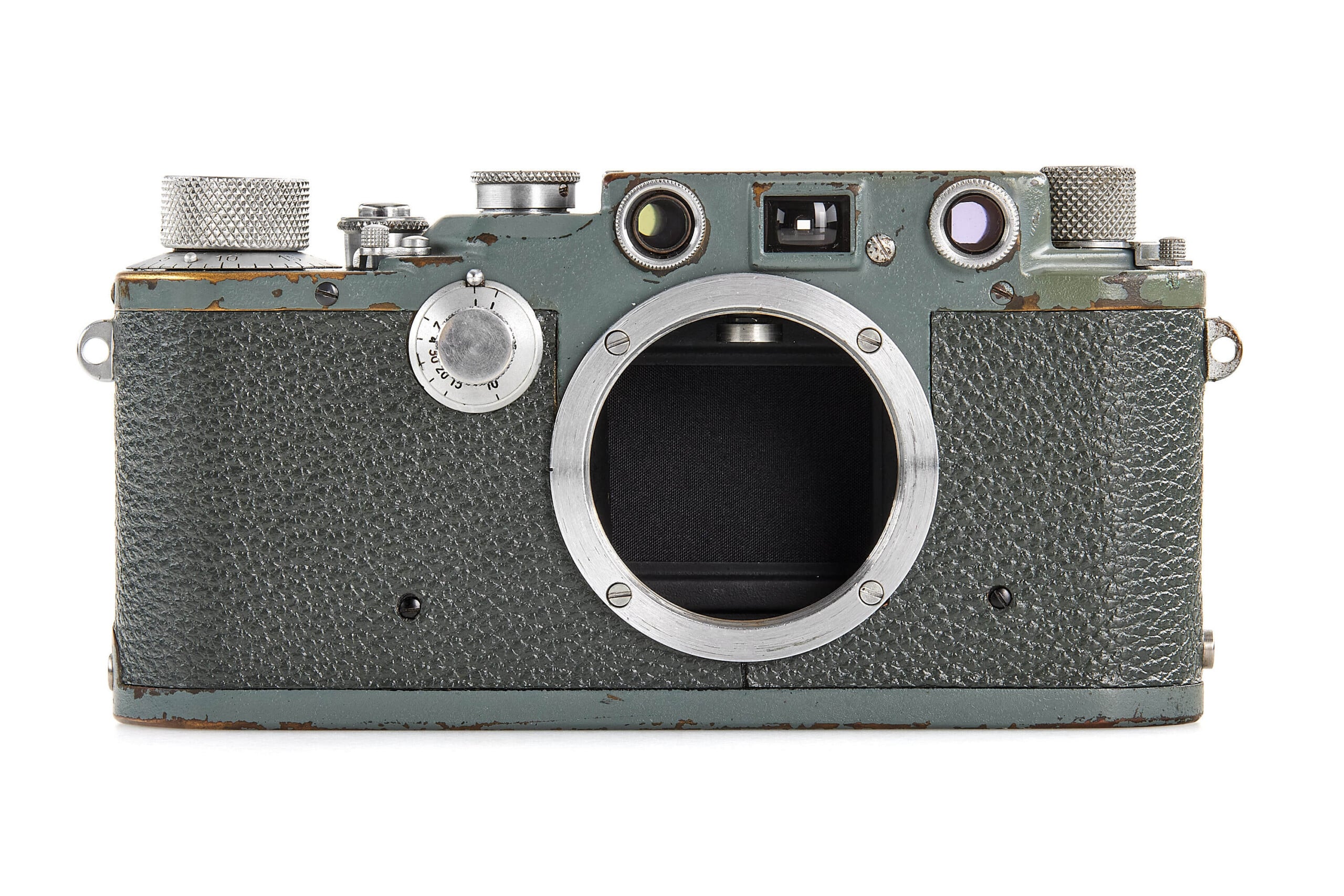 A vintage, weathered film camera body with a textured greenish surface and silver metal accents, showing visible signs of use and no lens attached.