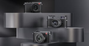Three black Leica cameras with red logos are displayed on staggered, curved metallic platforms against a dark, modern background.