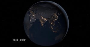 A view of Earth from space at night, showing illuminated city lights across Asia, including India, China, and Southeast Asia. The years "2014 - 2022" are displayed in the bottom left corner.