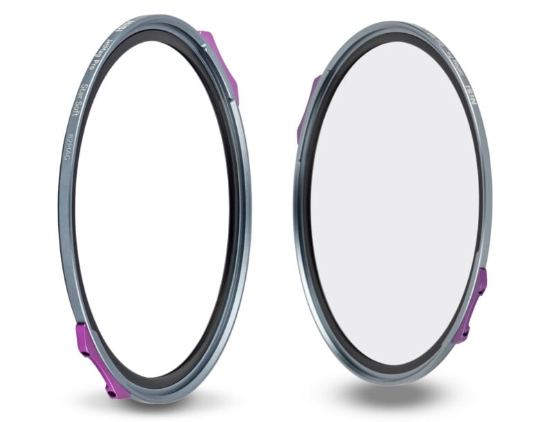 Two circular camera lens filters with thin metallic frames, each featuring a small purple tab on the side, are shown standing upright on a white background.