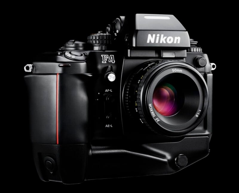 A close-up of a Nikon F4 film camera with a 50mm lens, shown against a black background, highlighting the camera's buttons, dials, and branding in sharp detail.