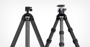 Two carbon fiber tripods with black legs are shown standing side by side against a white background. Each has a different style of tripod head mounted on top.