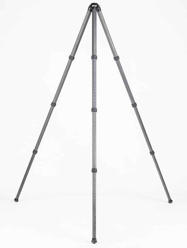 A tall, three-legged camera tripod with extendable legs is standing on a white background. The tripod is made of lightweight, textured material and does not have a camera or mount attached.