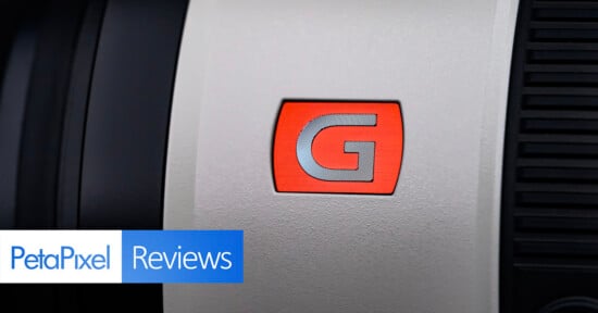 Close-up of a camera lens with a red "G" logo. The "PetaPixel Reviews" logo is in the bottom left corner.