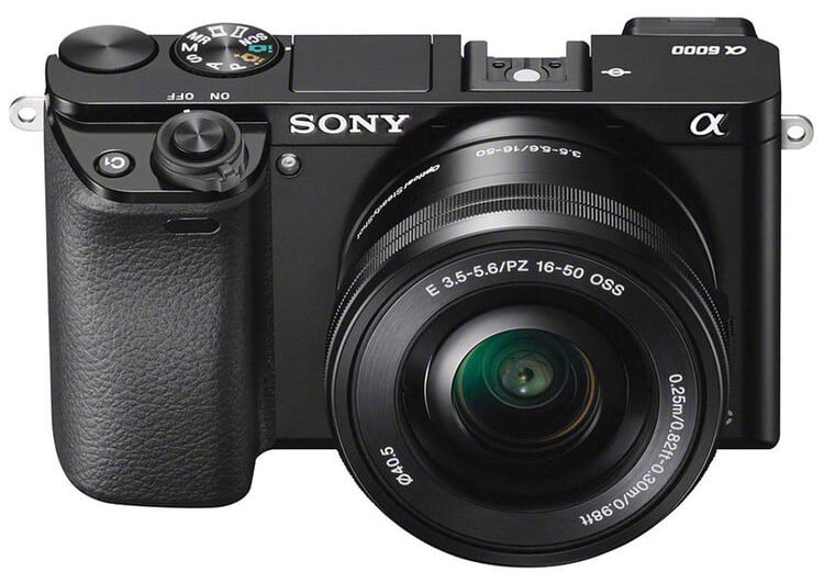 A black Sony Alpha a6000 mirrorless digital camera with a 16-50mm zoom lens attached, shown from the front with visible branding and controls.
