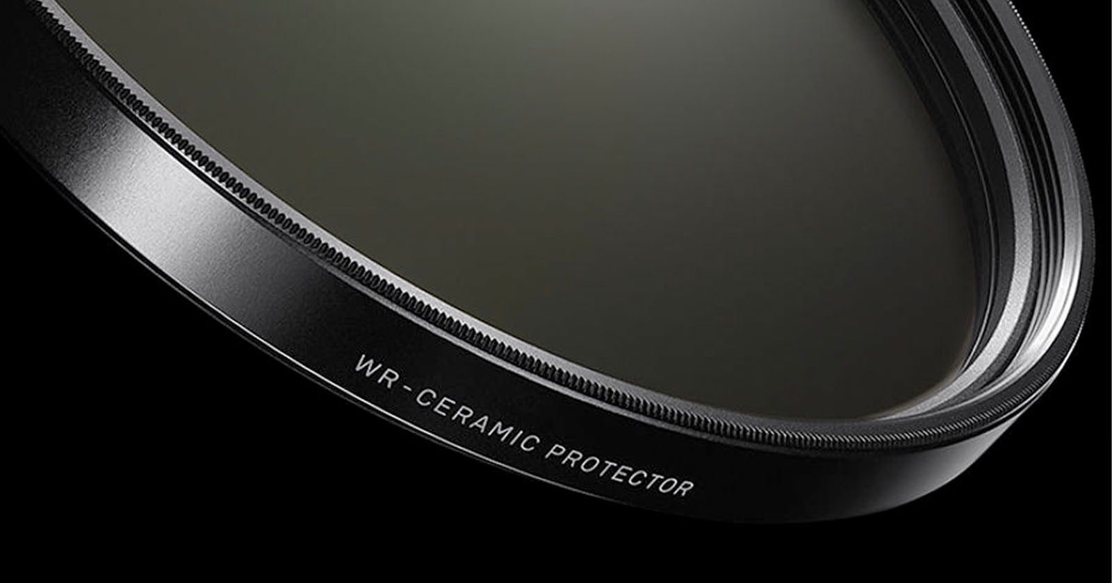 Close-up view of a camera lens filter labeled "WR-CERAMIC PROTECTOR" against a black background, showing the detailed edge and smooth glass surface.