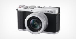 A silver and black Lumix digital camera with a large lens facing forward, positioned against a plain white background.