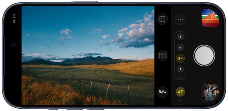 A smartphone screen displays a camera app with a scenic landscape viewfinder showing grassy fields, a fence, rolling hills, and a blue sky with clouds. Camera settings and controls are visible on the right.