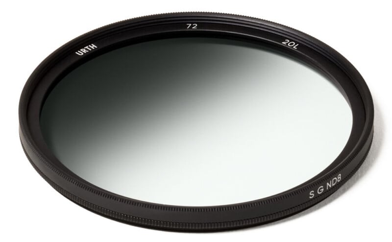 A circular neutral density camera lens filter with a thin black frame labeled "URTH" and "ND8," showing a gradient dark tint, placed on a white background.