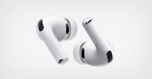Two white wireless earbuds with silicone ear tips are shown against a plain light background, positioned at different angles to display their sleek design and black vent details.