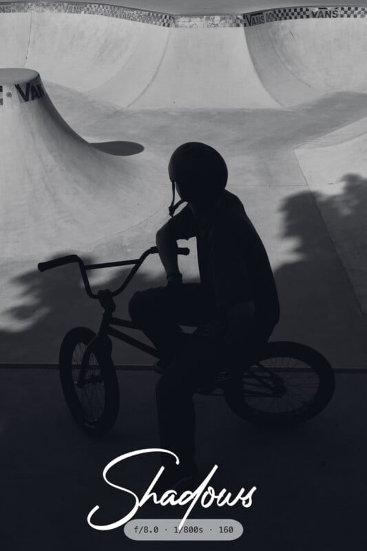 A silhouette of a person wearing a helmet sits on a BMX bike at a skatepark, with curved ramps and deep shadows visible. The word "Shadows" and camera settings are overlaid at the bottom.