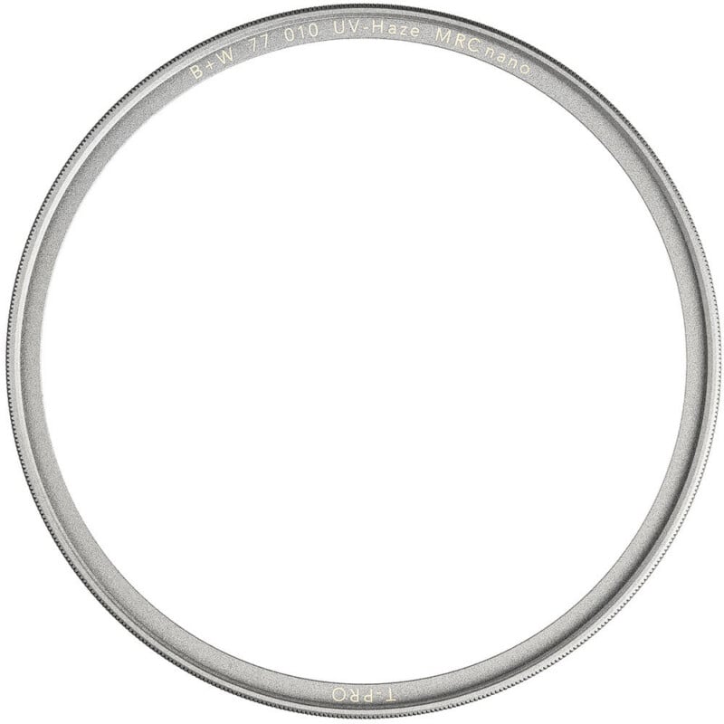 A close-up of a circular B+W UV Haze MRC nano 77mm camera lens filter with a thin metallic frame and engraved text along the outer edge, set against a white background.