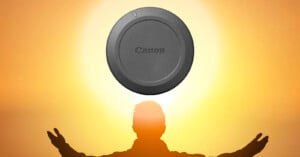 A silhouette of a person with arms raised stands in front of a glowing orange sky, with a Canon lens cap positioned above their head, resembling a halo or the sun.