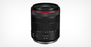 A black Canon RF 20-50mm camera lens with a red ring near the top, textured focus and zoom rings, and white focal length markings, displayed against a plain white background.