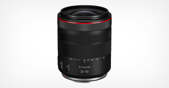A black Canon RF 20-50mm camera lens with a red ring near the top, textured focus and zoom rings, and white focal length markings, displayed against a plain white background.
