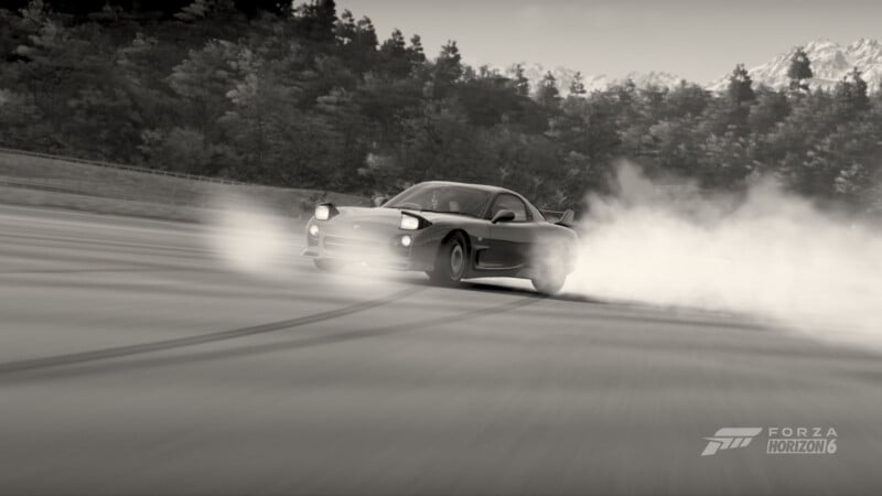 A black and white image of a sports car drifting on a track, producing smoke from the rear tires with tire marks visible on the ground. Trees and mountains are in the background, with the Forza Horizon 6 logo in the corner.