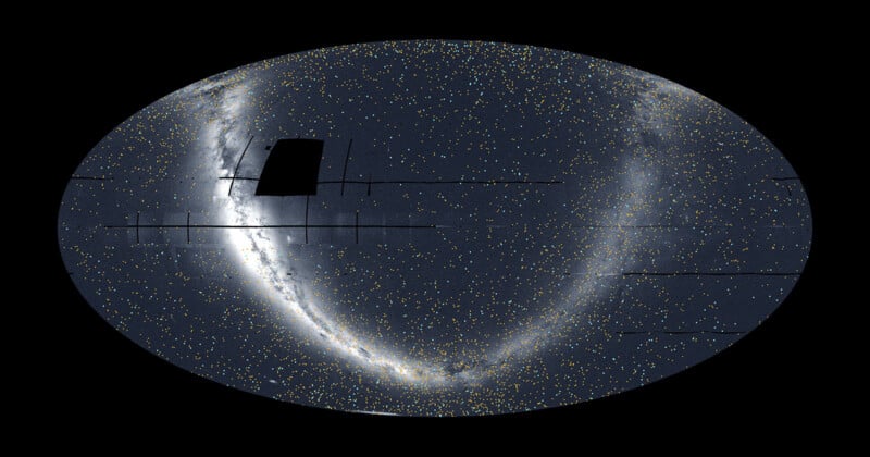 A wide, oval-shaped map of the night sky filled with tiny stars. A dense, bright arc of stars curves from the top left to the bottom right. A dark rectangular patch appears near the top left within the star field.