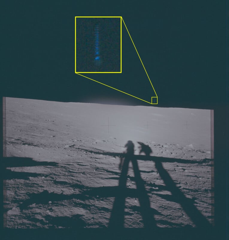 Two astronauts cast long shadows on the Moon's surface; a small, highlighted inset shows a close-up of a faint blue streak in the sky above the lunar horizon.