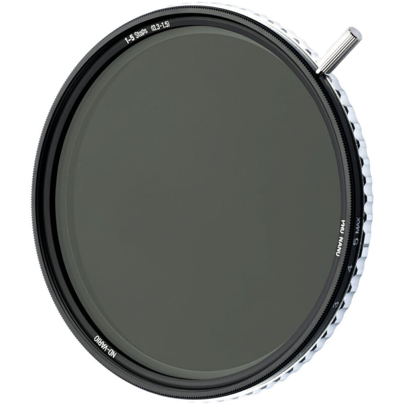 A circular camera lens filter with a black frame, textured white edge, and a small silver lever extending from the rim, labeled with markings indicating filter strength.
