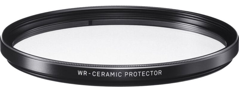 A black circular camera lens filter labeled "WR - CERAMIC PROTECTOR" with a clear center against a white background.
