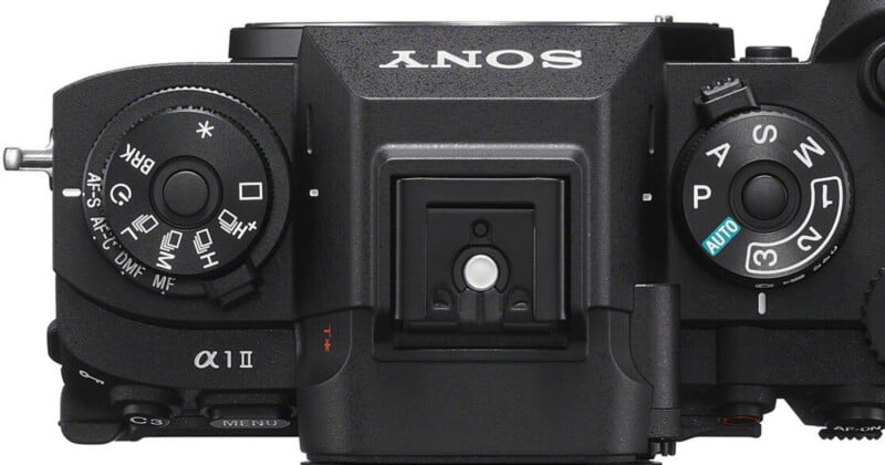 Top view of a Sony Alpha a7 II camera showing various control dials, including mode, exposure compensation, focus mode, and menu buttons, with the Sony logo visible on the body.