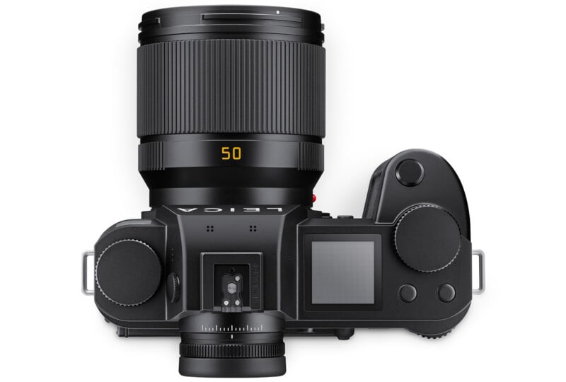 Top view of a black Leica digital camera with a 50mm lens attached, showing controls, dials, an LCD screen, and the lens with "50" displayed in yellow on the barrel.