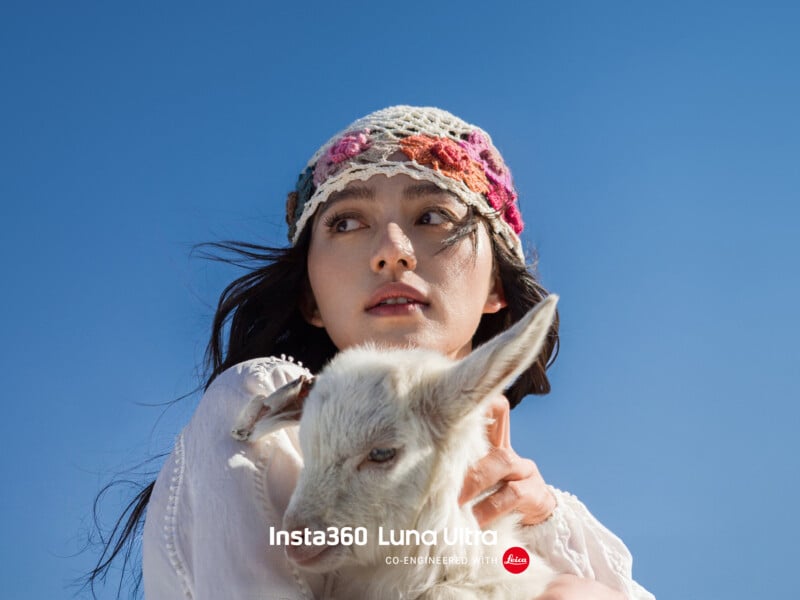 A woman wearing a floral crocheted hat holds a white baby goat against a clear blue sky. The text "Insta360 Luna Ultra" and the Leica logo appear at the bottom of the image.