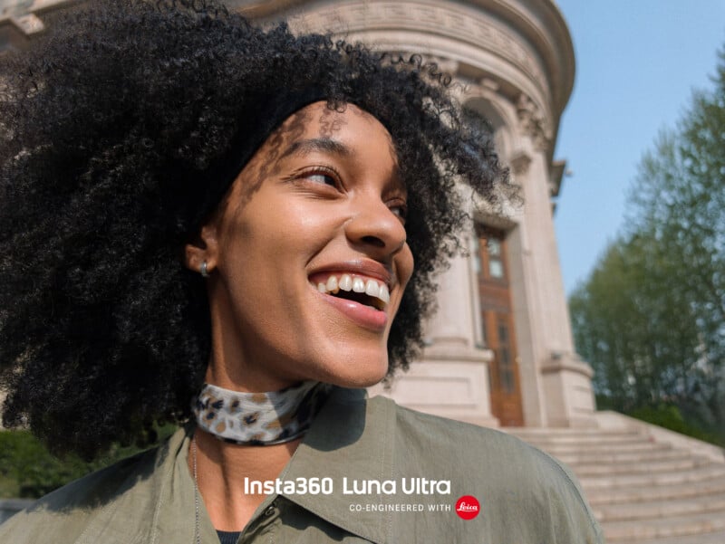 A smiling person with curly hair stands outside in sunlight, in front of a historic stone building with arched windows and stairs. The text reads “Insta360 Luna Ultra co-engineered with Leica.”.