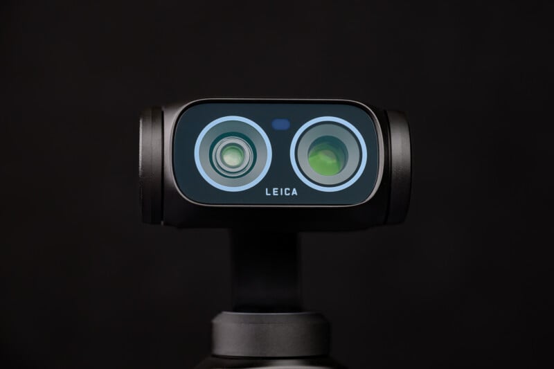A close-up view of a Leica device with two camera lenses, resembling eyes, set against a plain black background.