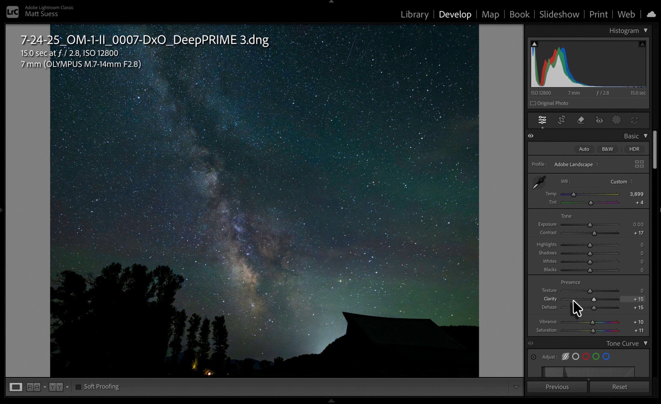 A computer screen displays Adobe Lightroom with a photo of the Milky Way over a silhouetted landscape. Editing panels are open on the right, showing sliders for exposure and color adjustments.
