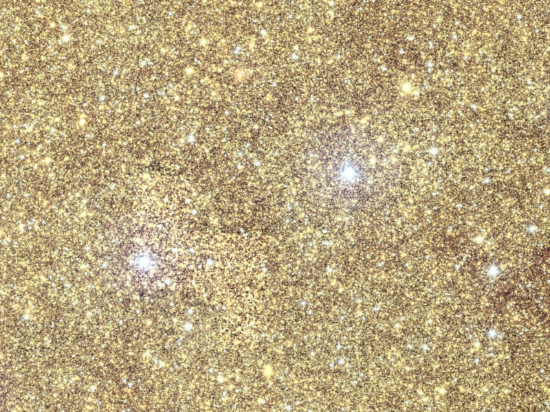 Vista de cerca de una textura brillante de brillo dorado con pequeñas motas reflectantes y reflejos esparcidos por la superficie creando un efecto festivo brillante.