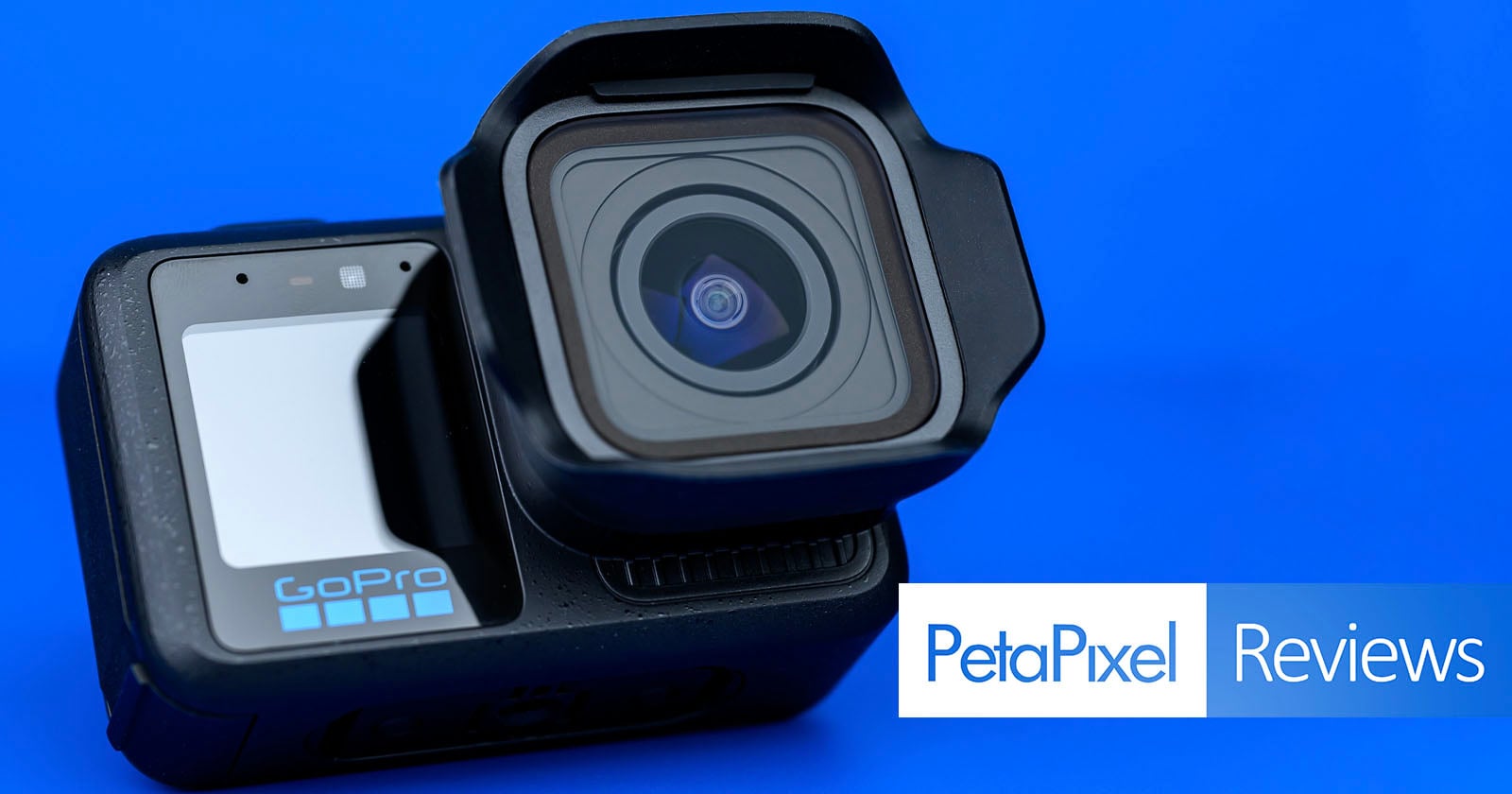A GoPro action camera with a lens cover is positioned on a blue background. The words "PetaPixel Reviews" appear in white and blue text in the lower right corner.