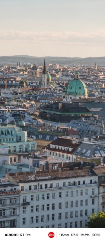 A cityscape view of Vienna with historic buildings, domes, and church spires under a clear sky, taken during daylight from an elevated vantage point.