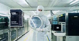 A person in a cleanroom suit holds a silicon wafer in a high-tech lab, with a large 128GB Lexar Professional SD card image superimposed on the left.